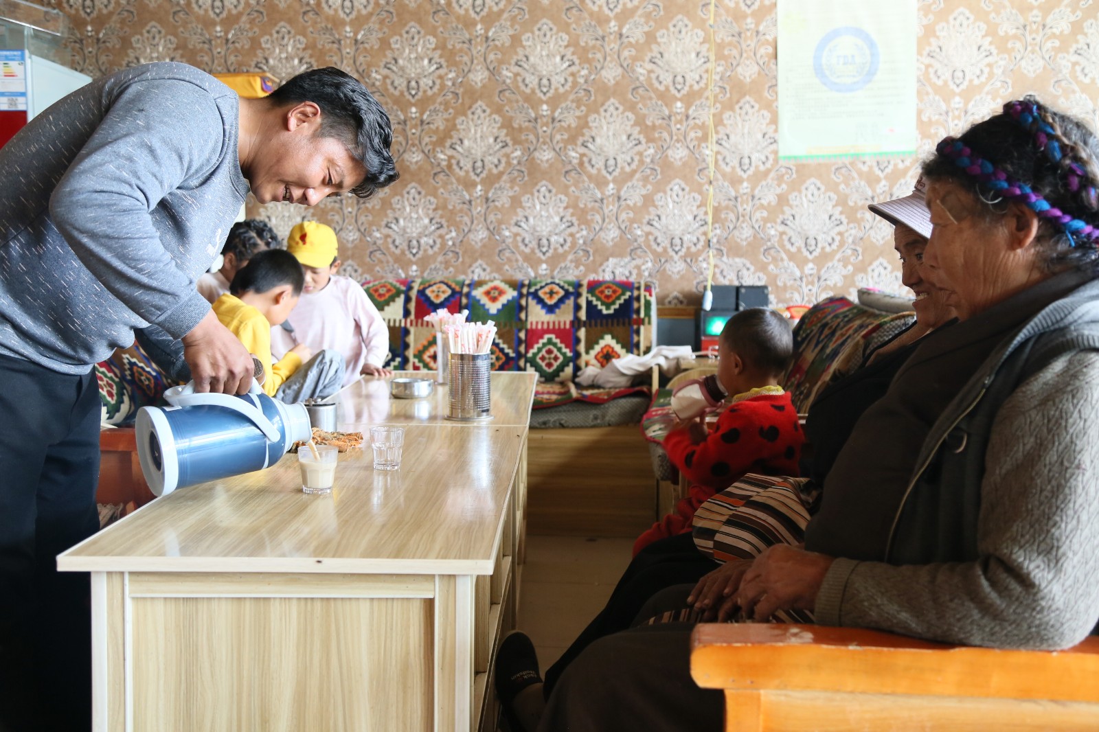 图为仁增在自己开的藏餐馆里给消费者倒茶。.JPG 图为仁增在自己开的藏餐馆里给消费者倒茶。.JPG