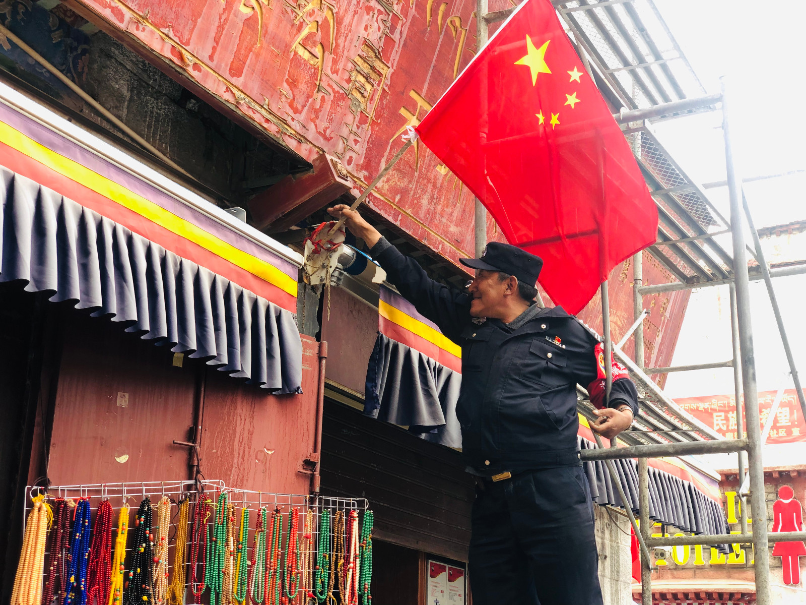 yj0909p05城关区冲赛康社区居委会工作人员正在为沿街商铺插红旗。.jpg yj0909p05城关区冲赛康社区居委会工作人员正在为沿街商铺插红旗。.jpg