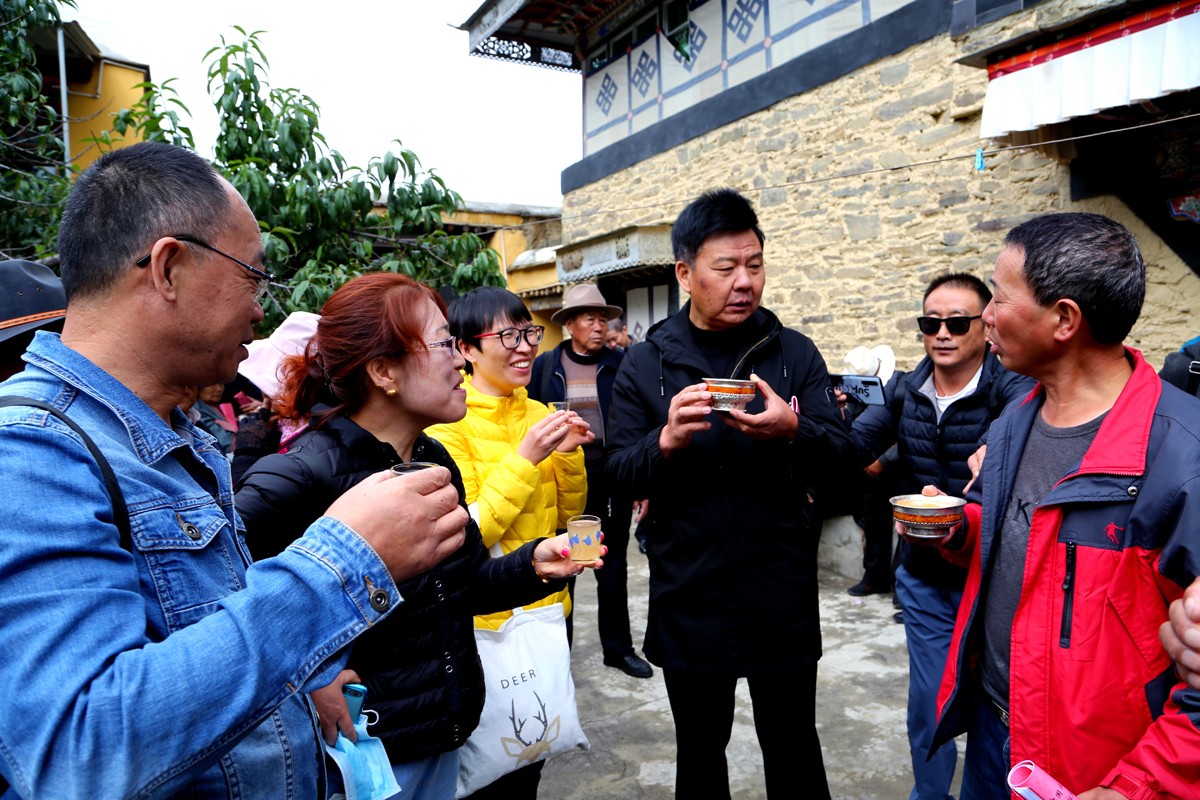 离退休干部正在强吉村品尝青稞酒 (1).jpg