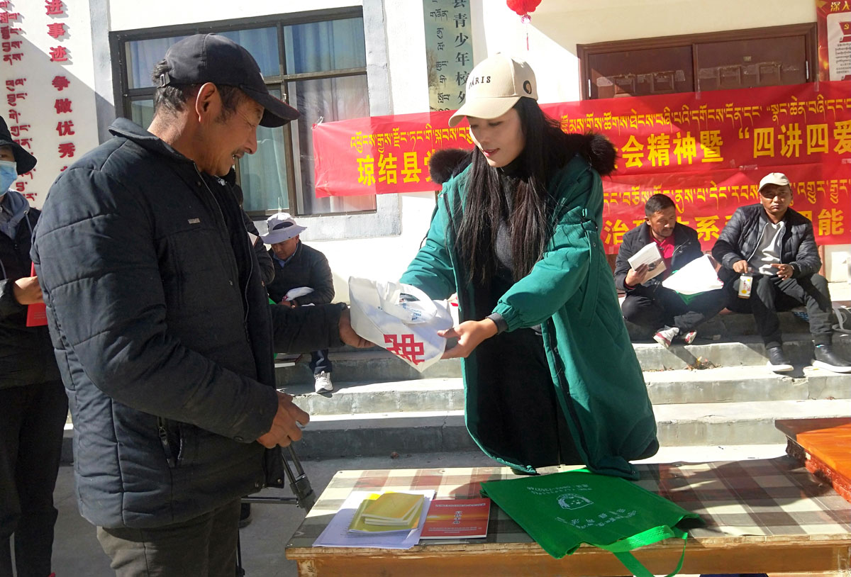 县“四讲四爱”办公室工作人员在现场发放宣传资料.jpg